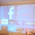 Duvarda geniş ekranda Wanbo T4 450 ANSI Android 9 Akıllı Projeksiyon Cihazının görüntülendiği bir oturma odası.